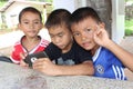 Three boys are watching the interest at a telephone.